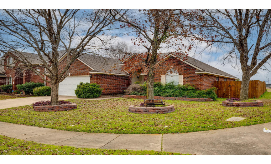 Excellent curb appeal with well-maintained landscaping, three robust shade trees, red brick masonry, and a two-car garage.