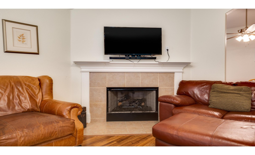 Featuring a lovely wood-burning fireplace framed in tile with a decorative wood mantlepiece.