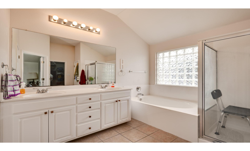 The primary suite comes complete with this large, private ensuite bathroom. Featuring a dual vanity with well maintained cabinetry, private commode, linen closet, and walk-in closet. 