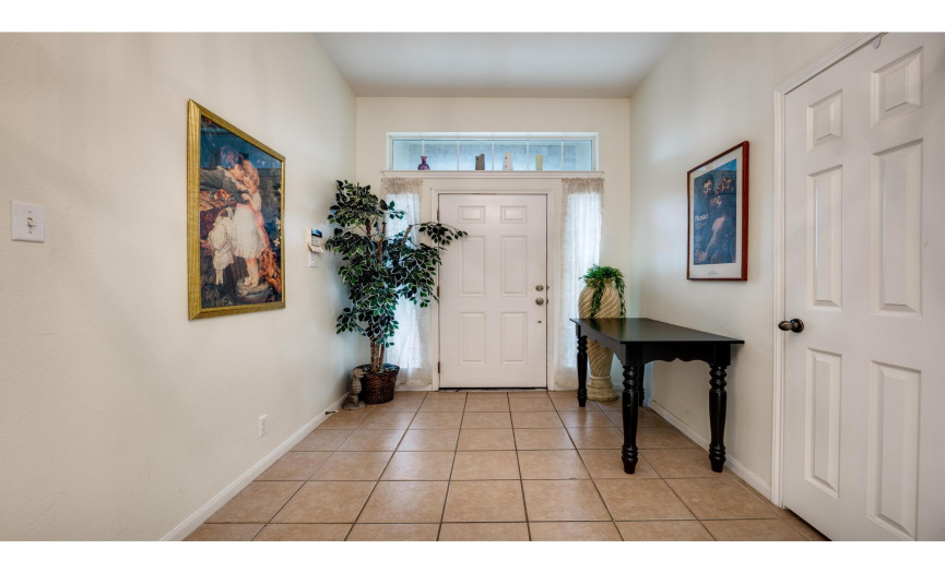 Step inside to discover a gracious entry foyer with tall ceilings, ceramic tile floors and a storage closet. 
