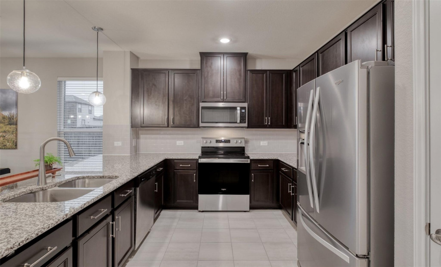 Replete with granite counters, espresso cabinetry, and stainless-steel appliances, the home chef will love to cook in this kitchen.