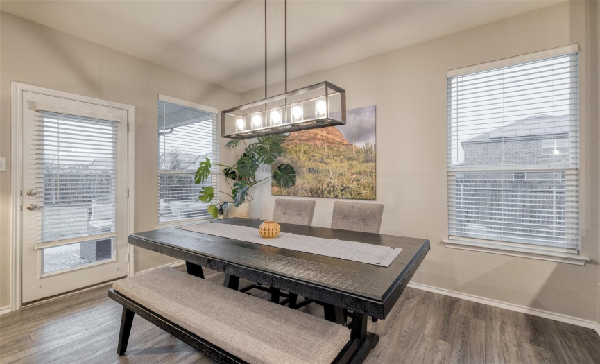The dining area is positioned adjacent to the kitchen and features a lovely hanging light fixture.