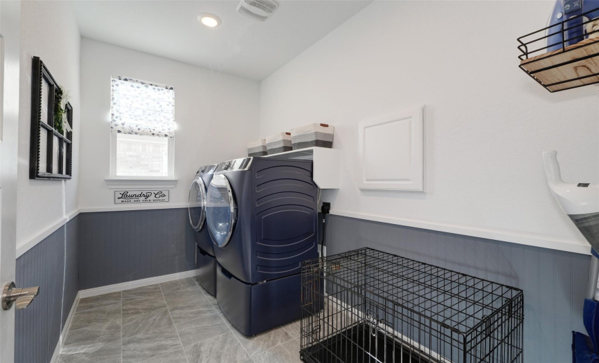 The laundry room has plenty of space for a dog kennel and/or a laundry hamper just under the pass-through window to the primary closet.