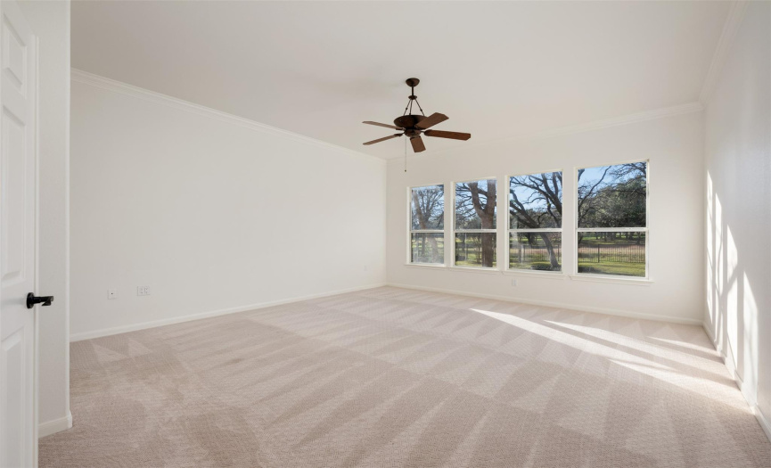 The primary bedroom overlooks the private back-yard with views of natural landscape and the golf course.