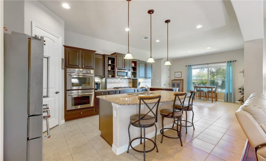 Gourmet kitchen features granite countertops and stainless steel appliances