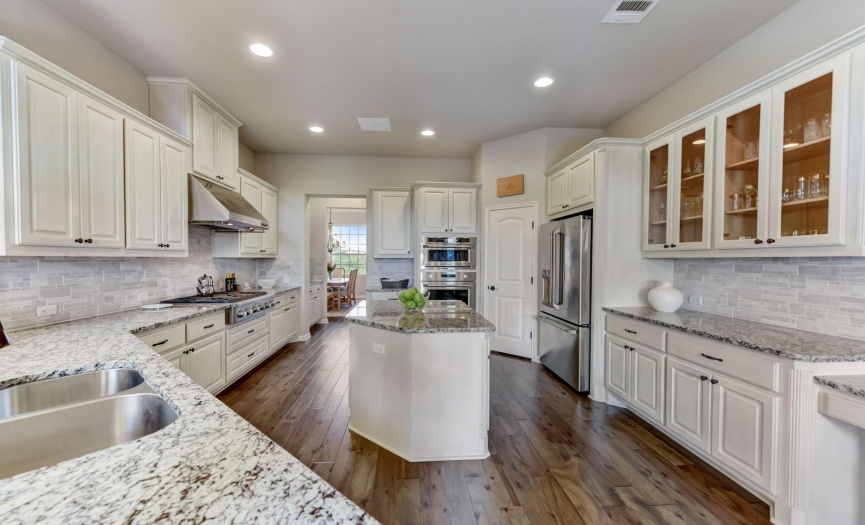The gourmet kitchen is both stylish and functional, boasting high-end finishes throughout