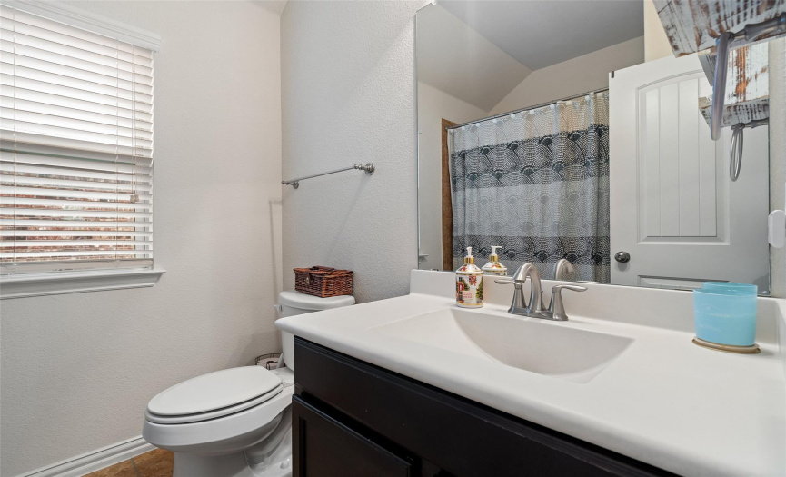 Shared bathroom that comes with both a shower and soaking bathtub.