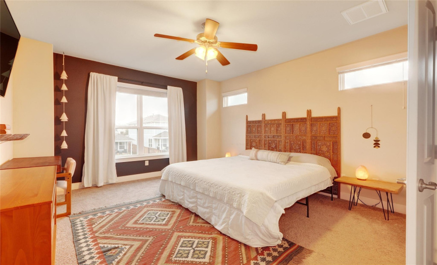 The large main bedroom serves as a peaceful sanctuary full of natural light. It features a walk in closet and carpet for additional comfort and quiet.