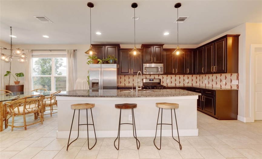 The kitchen's open layout, large island / breakfast bar, and stainless steel appliances create an ideal space for both cooking and entertaining.