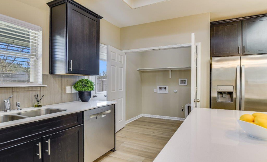 The sink area overlooks the patio and back yard to monitor activities there.  The laundry closet is conveniently close; laundry can be tucked away out of sight when desired.