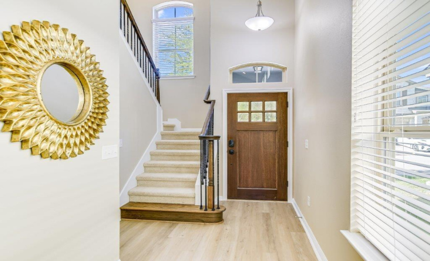 The staircase is adjacent to the entry foyer and features a decorative iron and wood railing, one of the many upgrades in the home. 