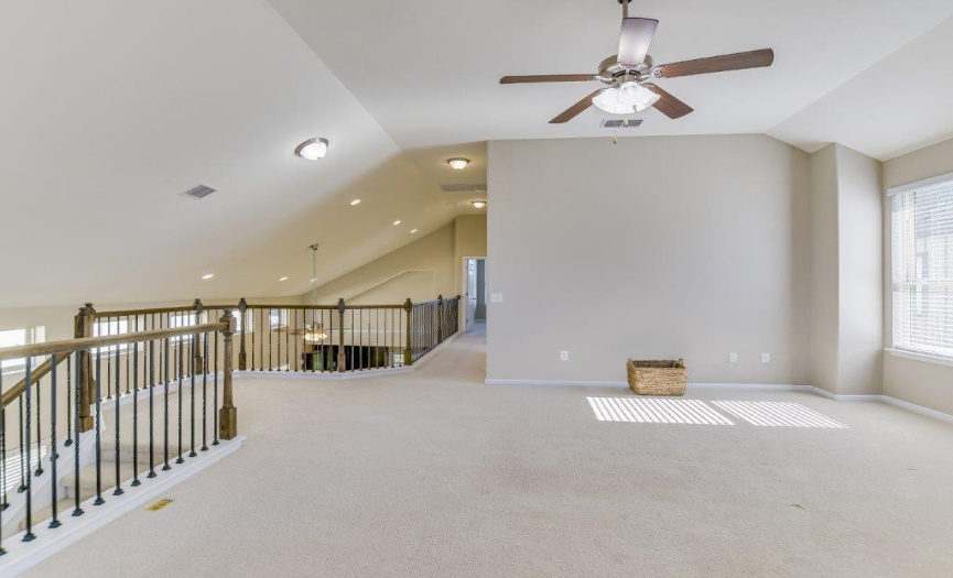 Both of the living areas in the home include ceiling fans for comfort and energy efficiency.  The decorative iron and wood railing extends the length of the second-story overlook.