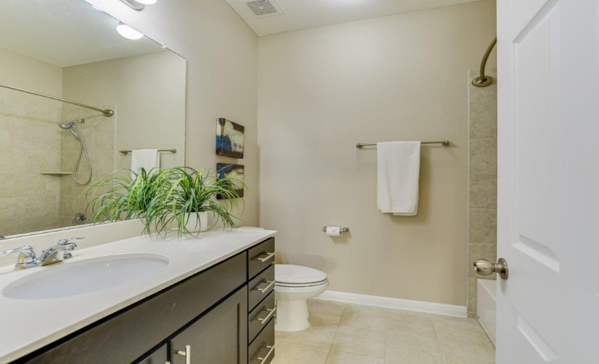 The hall bath between the secondary bedrooms features extra counter space and a tub/shower.