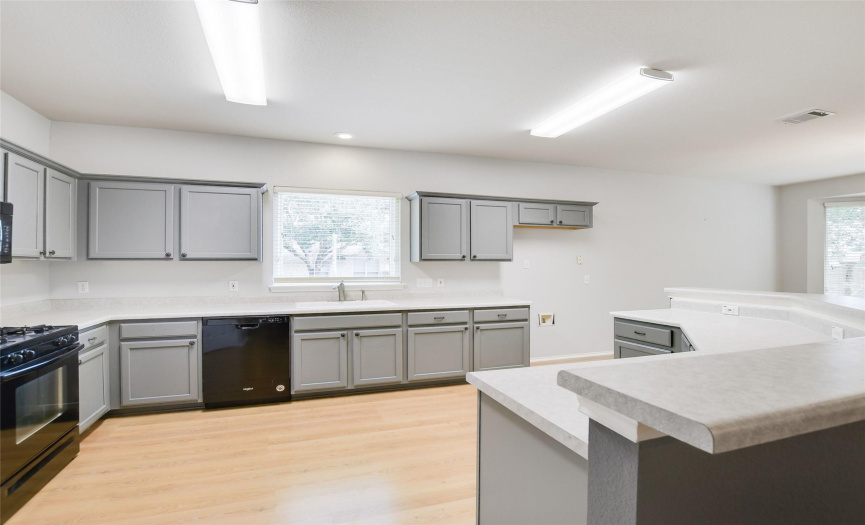 The kitchen has an abundance of counter and cabinet space,  providing  ample room for cooking and storage.