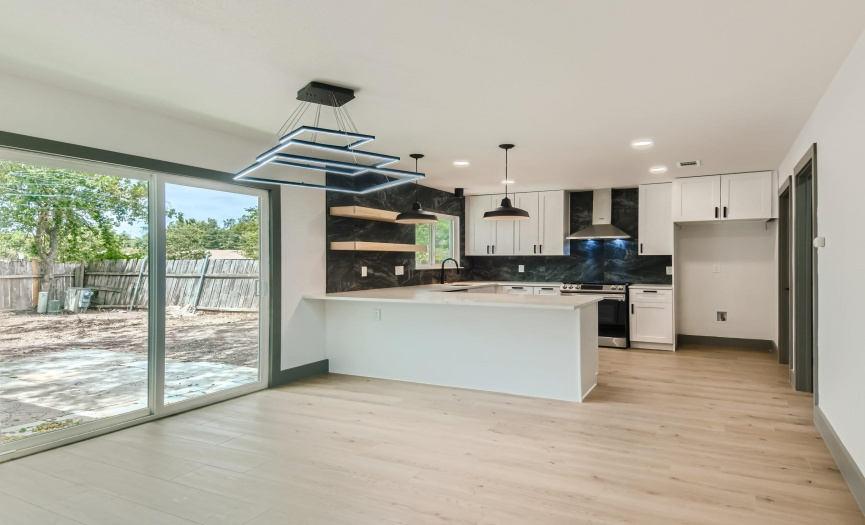 A wonderful dining area that looks into your beautiful kitchen and out through the new sliders into the backyard. Beautiful light fixtures were hand selected for this remodeled home.