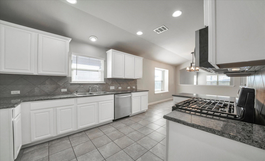 Stainless steel appliances and granite countertops in kitchen at 401 Purple Martin