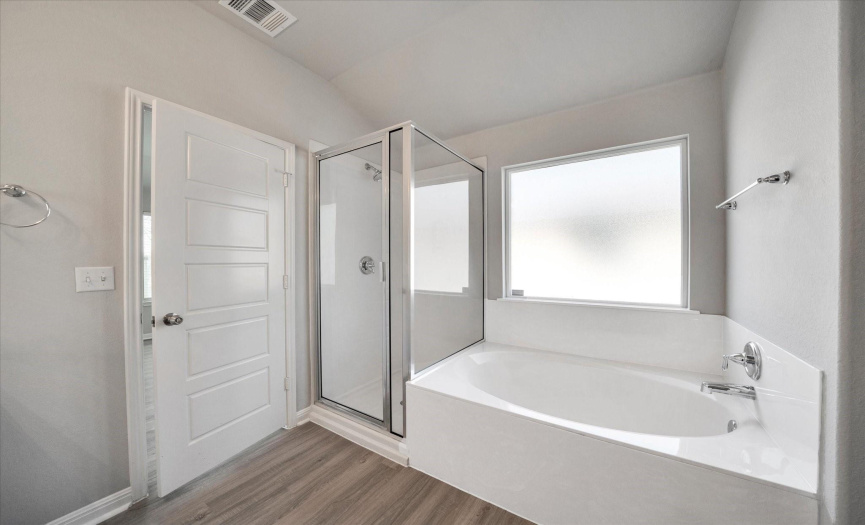 Walk-in shower and tub in primary bathroom at 401 Purple Martin