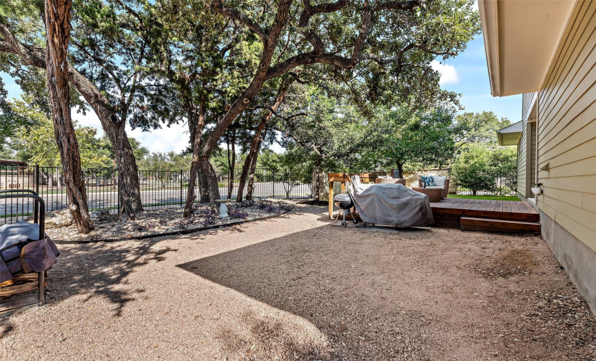 The back yard has crushed granite on one side of the deck perfect for a playset or firepit