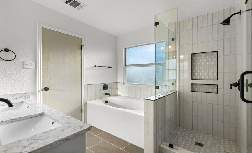 Primary bathroom remodeled with gorgeous modern finishes with black fixtures. 
