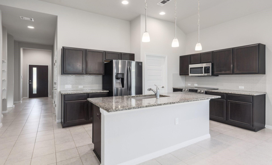 The perfect kitchen with granite countertops, and an island with an overhang that can easily seat four guests that want to watch you put the finishing touches on a fabulous meal