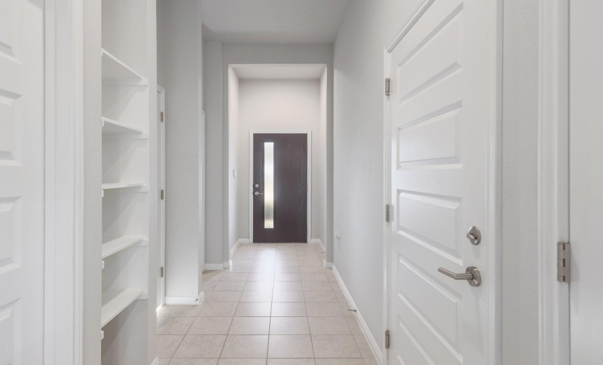 The entryway boasts natural light from the contemporary door and display shelving