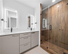 The en-suite bath also features an oversized walk-in shower with a frameless glass enclosure. 