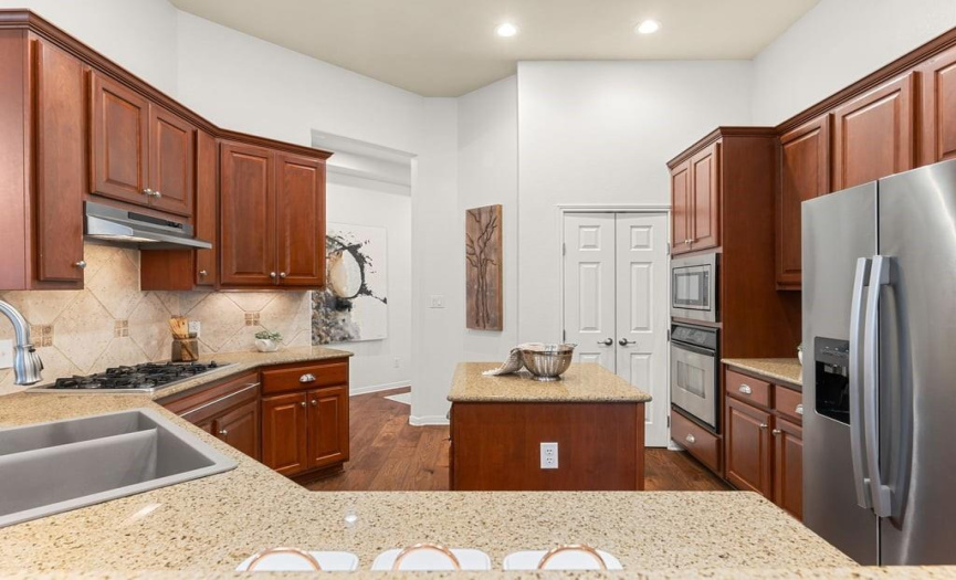The dedicated utility room is located off the of the kitchen (behind the double doors) and includes laundry and storage.