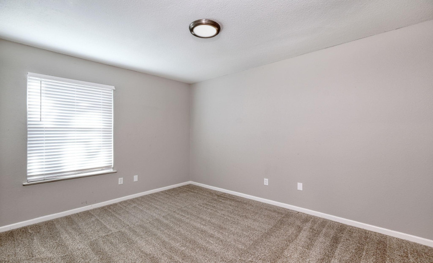 The third bedroom has one large window for natural light, and carpet throughout.