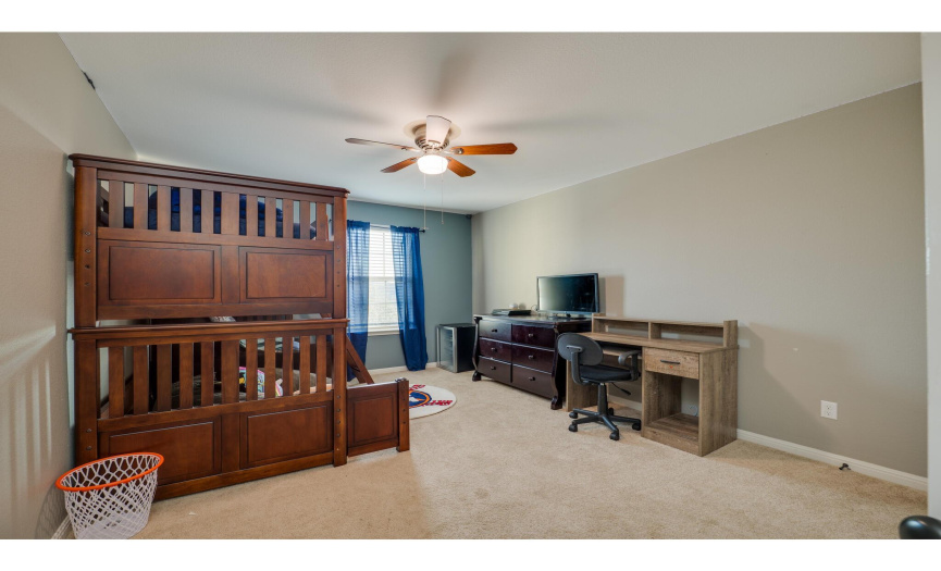 One secondary bedroom is sizable and centered by a ceiling fan.