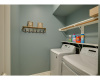 The laundry room offers two shelves and a handing rod for organization.