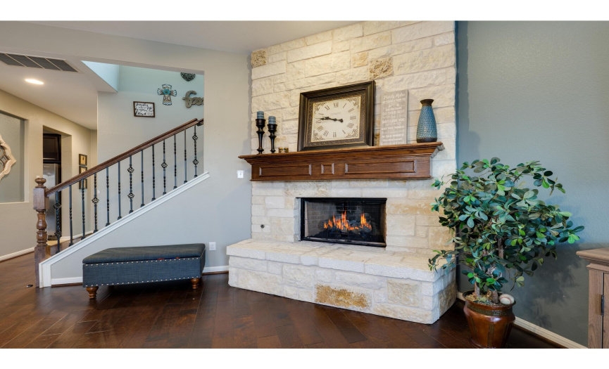 A cozy stone fireplace serves as the focal point in the living room.