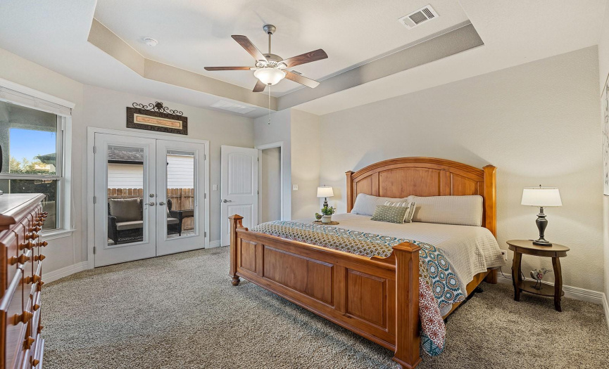 The primary suite is conveniently located off the kitchen and has beautiful french doors out to the patio.