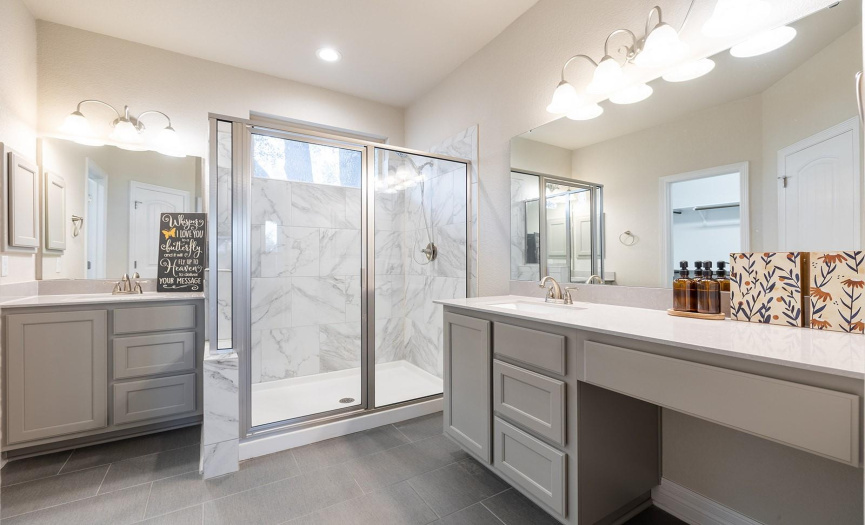 Primary bath includes two vanities and a large walk in shower.