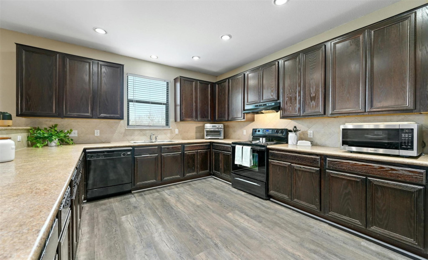 The home chef will appreciate the expansive countertops, tile backsplash, plentiful cabinetry and counter space, and bonus café counter.