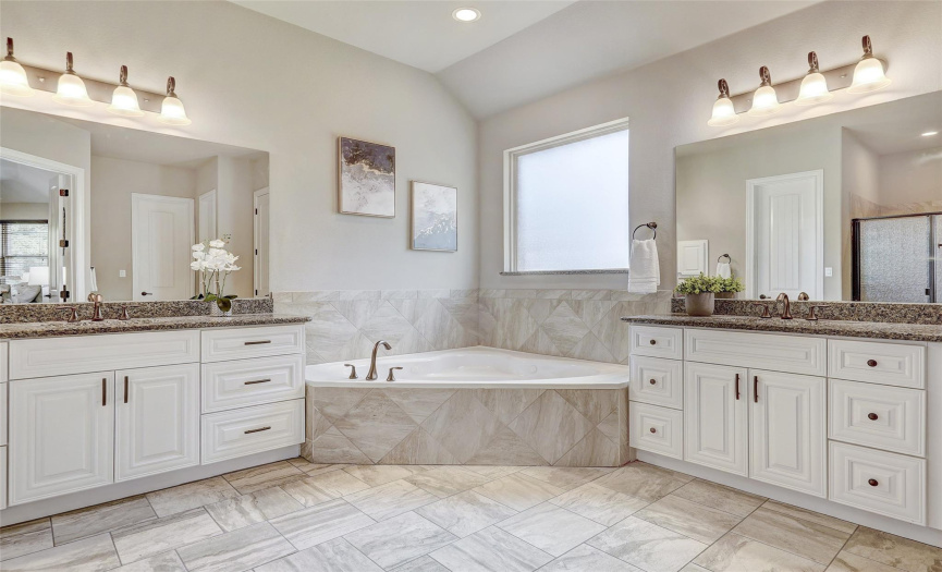 Remodeled Primary Bathroom with Dual Vanities, Soaking Tub, & His and Her Closets.