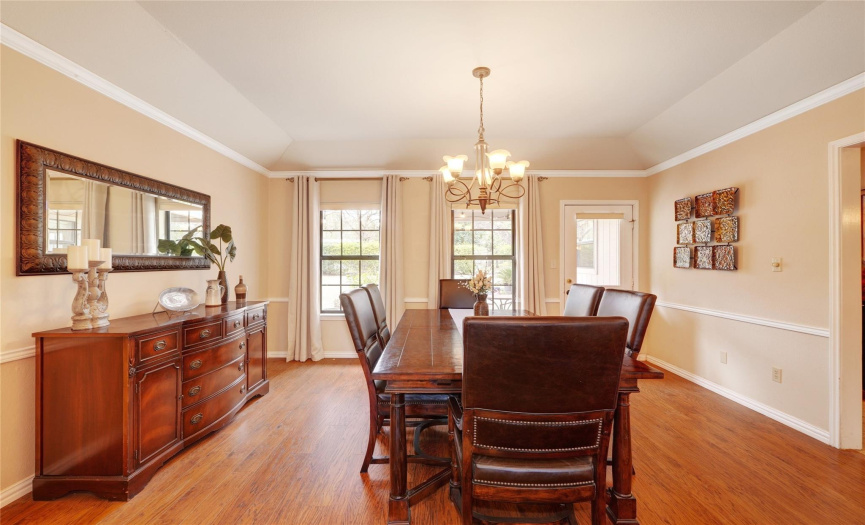 Spacious formal dining area provides plenty of room for entertaining. Lovely chandelier, crown molding, and chair railing are all nice touches.