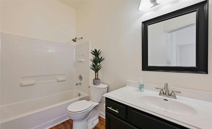 The full secondary bathroom featured updated luxury vinyl plank floors and provides a shower/tub combo with tile backsplash. 