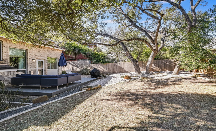 Wide and deep the tree-shaded back yard is surrounded by like-new wood privacy fencing. Room to entertain, play and enjoy being outside!