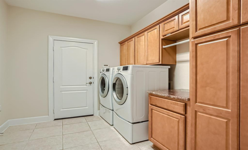 Big laundry room with counter and cabinet space.