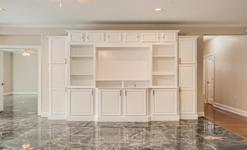 Built in entertainment center with shelves and cabinets for storage.