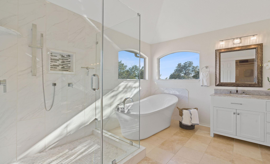 Modern soaking tub is  perfectly framed by the corner windows letting in incredible light and private treed views.