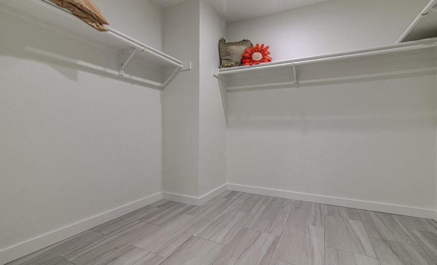 Primary closet with recent flooring and paint.