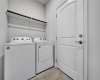 Laundry room leading to two car garage with storage space 
