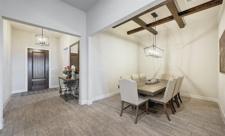 A formal dining room with beamed ceilings is positioned near the front of the home.