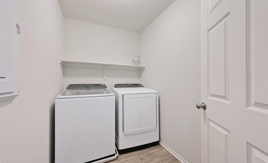 Efficiency meets organization in this well-appointed laundry room, featuring convenient shelving for easy storage.