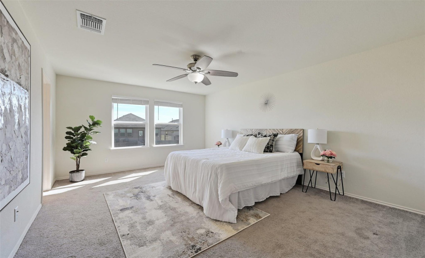 The generously sized primary bedroom welcomes you with a view of the meticulously designed space and high ceilings, ensuring a comfortable retreat.