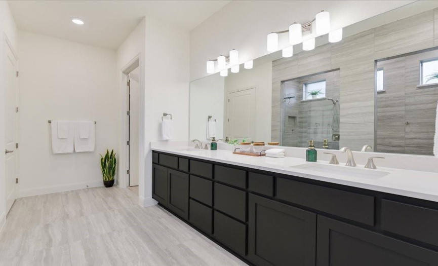 Very spacious primary bath with dual vanities and plenty of storage.  Private toilet area is located thru the door to the left of this photo and large closet is to the right.