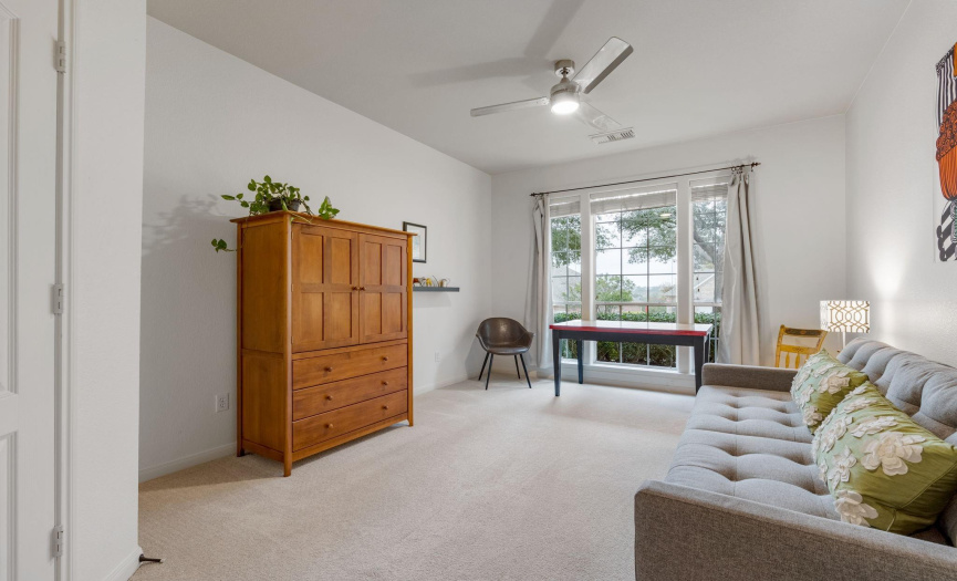 Located on the main floor, Bedroom 2 has a large window with two-inch blinds & curtains, aceiling fan, a standard closet, and an adjacent full bath.  Measures approx. 11x16