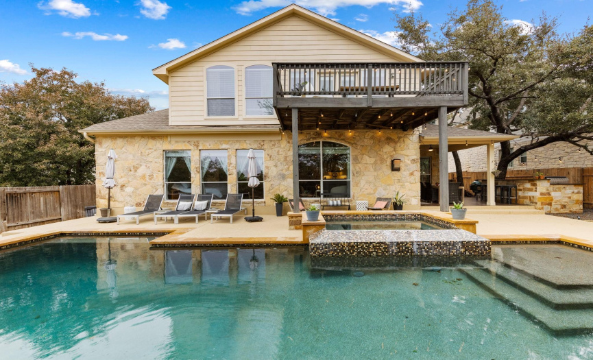 The focal point of the back yard is the pool and spa. There’s also an outdoor kitchen with gas grill, bar seating, and beverage refrigerator. In addition, there’s a firepit and a covered patio with tile flooring & ceiling fan. The property backs to an HOA-owned greenbelt.