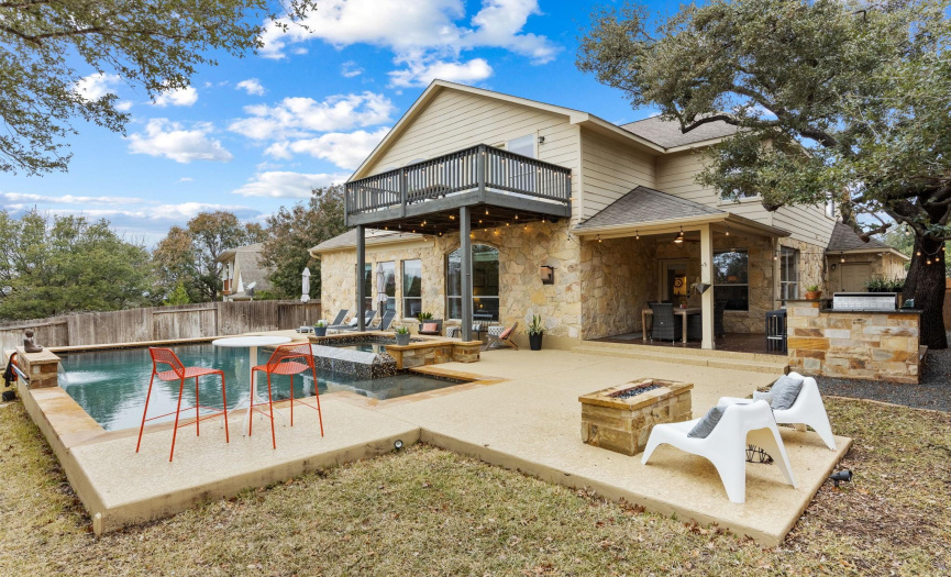 The focal point of the back yard is the pool and spa. There’s also an outdoor kitchen with gas grill, bar seating, and beverage refrigerator. In addition, there’s a firepit and a covered patio with tile flooring & ceiling fan. The property backs to an HOA-owned greenbelt.